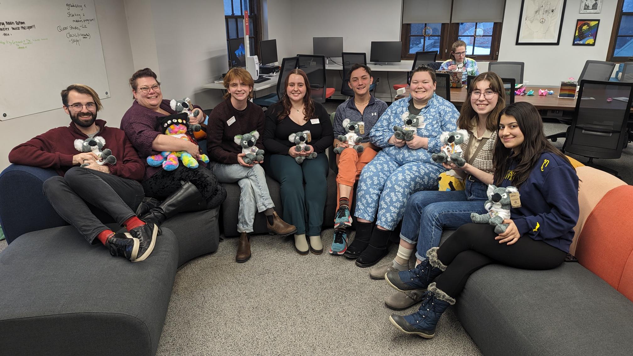 Center for LGBTQIA+ Student Success Full Staff holding Stuffed Koalas, sitting on the Rainbow Couch