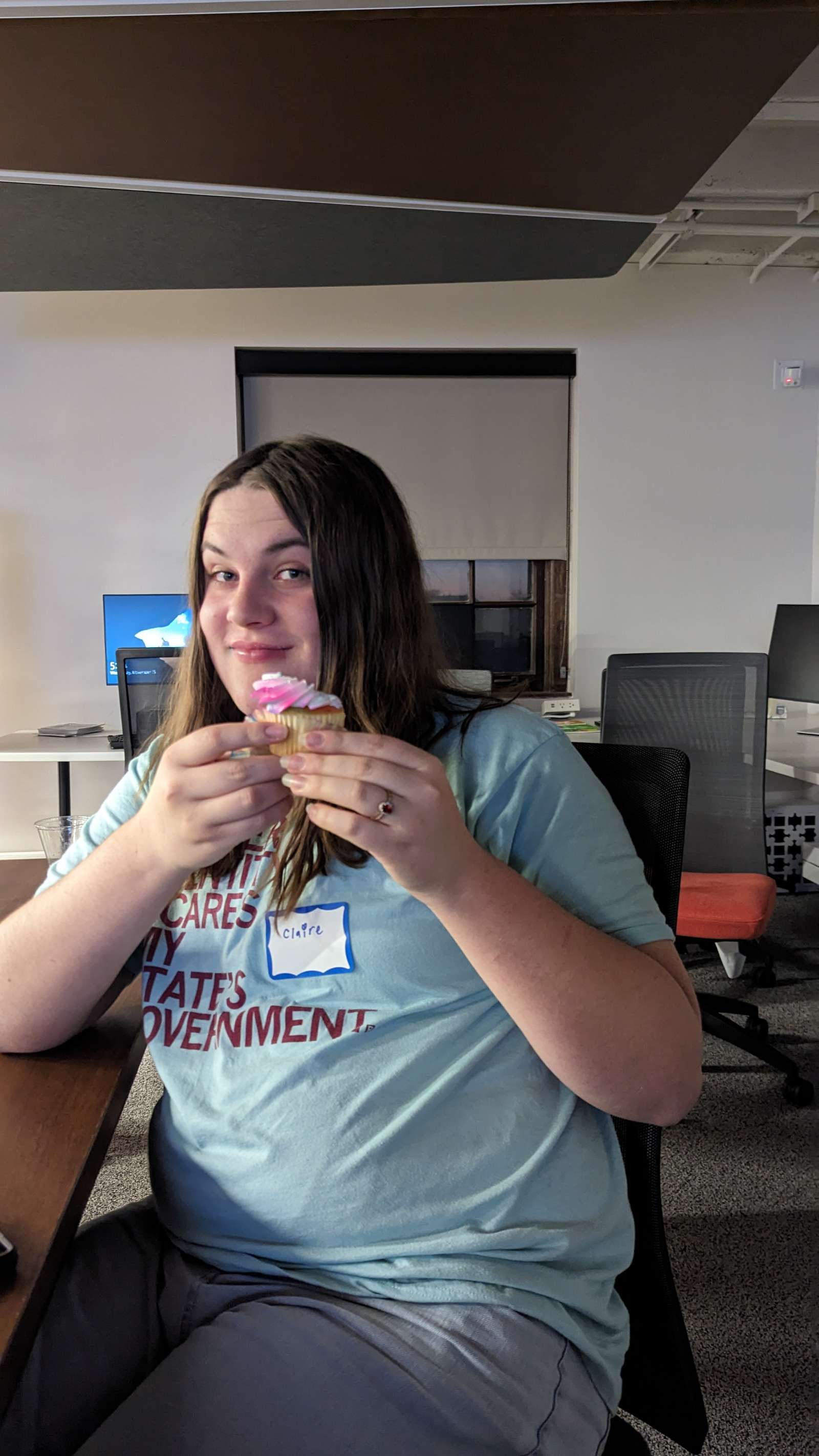 student holding cupcake with the colors of the trans pride flag: pink white and blue